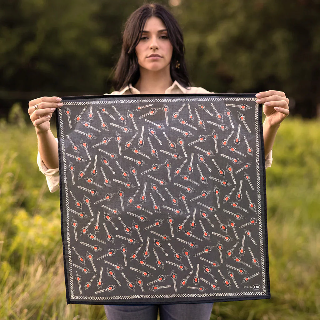 woman holding bandana. bandana is black with matches